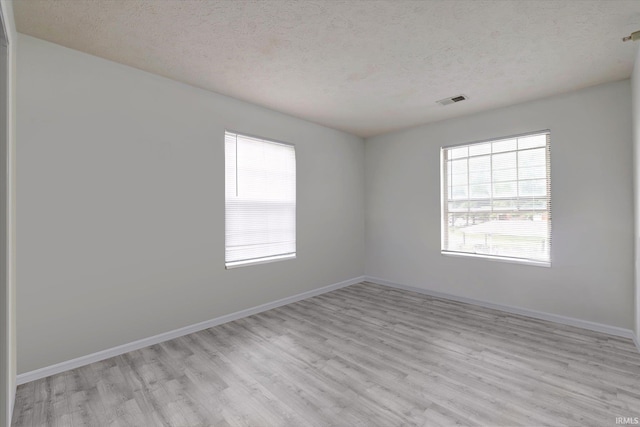 3220 E John Hinkle Pl Unit F, Bloomington, IN 47408 - unfurnished room with a textured ceiling, plenty of natural light, light wood-style flooring, and baseboards