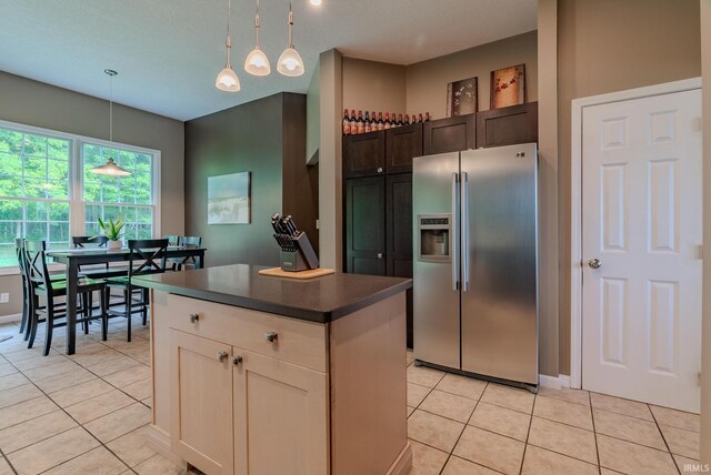 11600 S 700 E, Lafontaine, IN 46940 - kitchen with stainless steel refrigerator with ice dispenser, dark countertops, light tile patterned floors, a kitchen island, and hanging light fixtures