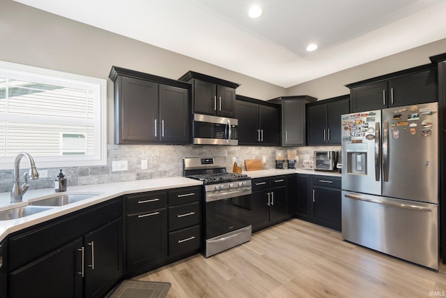 13909 Stone Table Blvd, Fort Wayne, IN 46845 - kitchen featuring appliances with stainless steel finishes, a sink, dark cabinetry, decorative backsplash, and light countertops