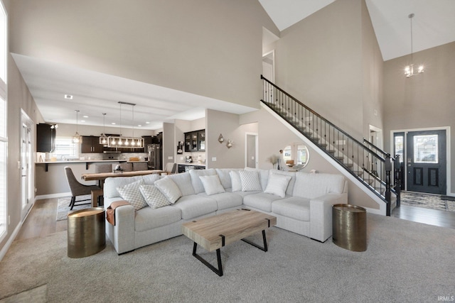 13909 Stone Table Blvd, Fort Wayne, IN 46845 - living area with a chandelier, light wood-type flooring, stairway, high vaulted ceiling, and baseboards
