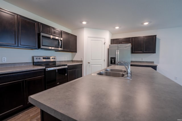 1208 Mount Isa Pl, Fort Wayne, IN 46845 - kitchen with stainless steel appliances, a sink, dark brown cabinetry, recessed lighting, and wood finished floors