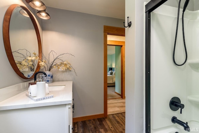 7819 Greenwell Rd, Churubusco, IN 46723 - ensuite bathroom with vanity, wood finished floors, shower / washtub combination, and baseboards