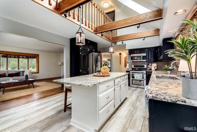 7819 Greenwell Rd, Churubusco, IN 46723 - kitchen with stainless steel appliances, a sink, a kitchen island, backsplash, and a kitchen breakfast bar