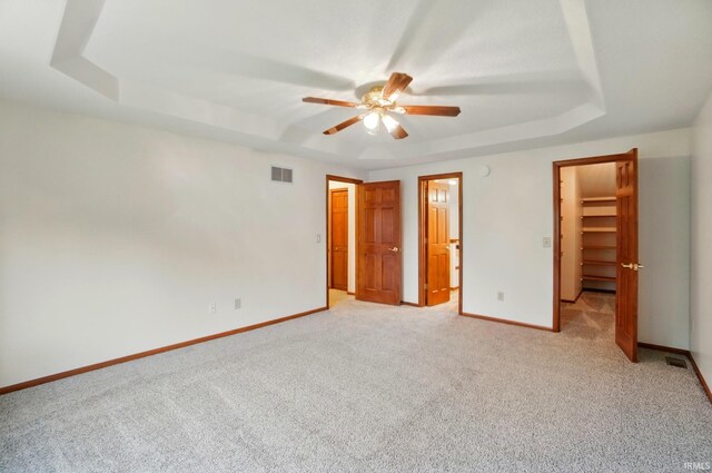 611 Big Valley Ct, Huntertown, IN 46748 - unfurnished bedroom featuring a raised ceiling, light colored carpet, baseboards, a spacious closet, and a closet