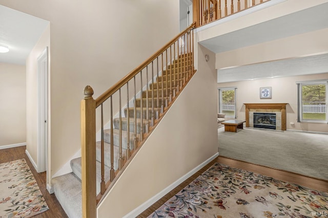 51062 Oak Hollow Ln, South Bend, IN 46628 - stairway with wood finished floors, baseboards, a tiled fireplace, and a high ceiling