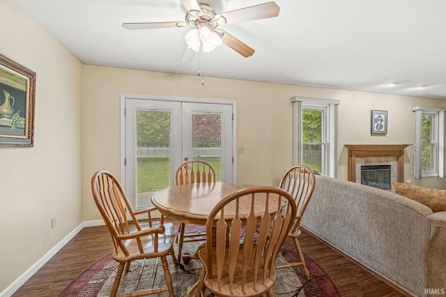 51062 Oak Hollow Ln, South Bend, IN 46628 - dining area with french doors, dark wood-style floors, a tiled fireplace, baseboards, and ceiling fan