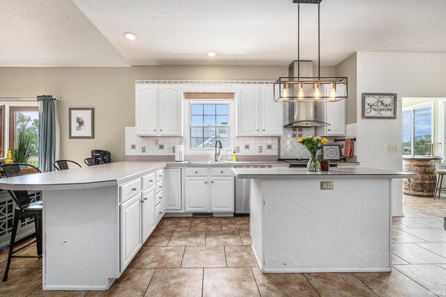 51405 Amesburry Way, Granger, IN 46530 - kitchen with a breakfast bar area, a sink, tasteful backsplash, white cabinets, and a peninsula