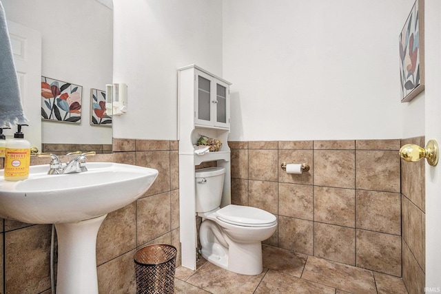 51405 Amesburry Way, Granger, IN 46530 - half bathroom featuring tile walls, toilet, a wainscoted wall, and tile patterned floors