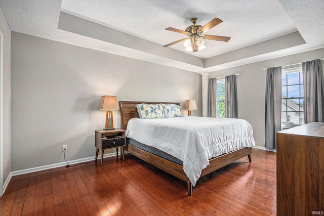 51405 Amesburry Way, Granger, IN 46530 - bedroom featuring a tray ceiling, baseboards, hardwood / wood-style flooring, a textured ceiling, and a ceiling fan