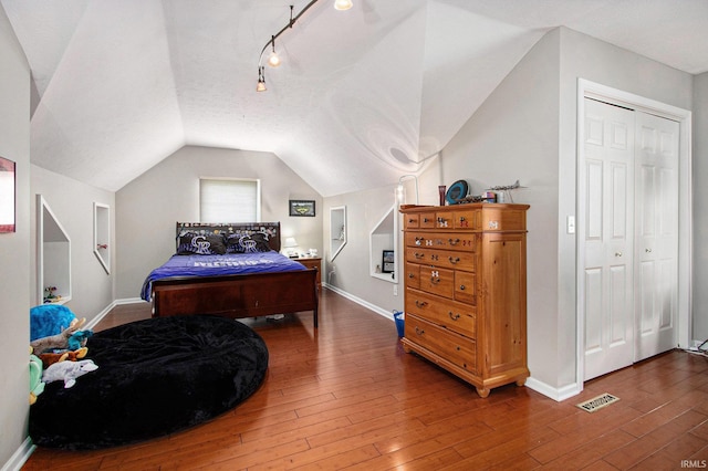 51405 Amesburry Way, Granger, IN 46530 - bedroom featuring baseboards, hardwood / wood-style floors, vaulted ceiling, and track lighting