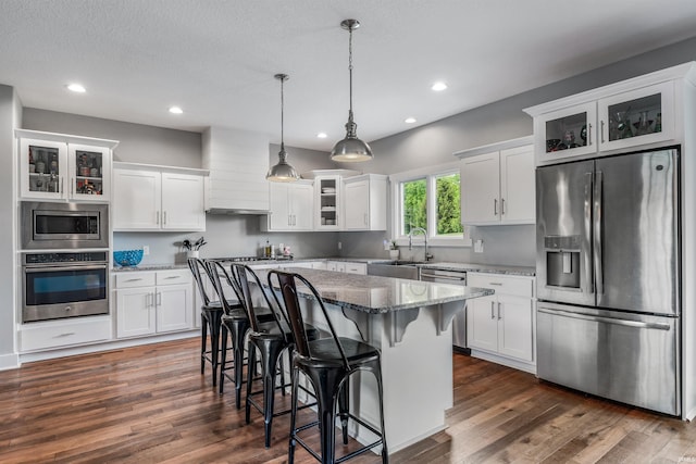 13606 Paperbark Trl, Fort Wayne, IN 46814 - kitchen with stainless steel appliances, dark wood-style flooring, white cabinets, a kitchen island, and recessed lighting