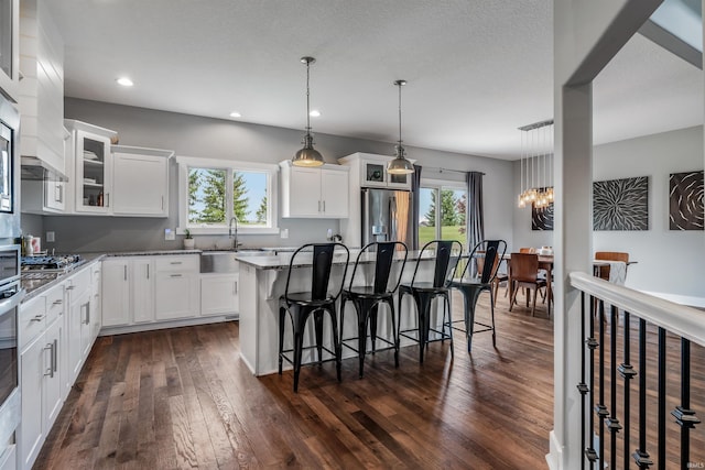 13606 Paperbark Trl, Fort Wayne, IN 46814 - kitchen featuring stainless steel fridge with ice dispenser, a sink, a kitchen island, dark wood-style floors, and a breakfast bar