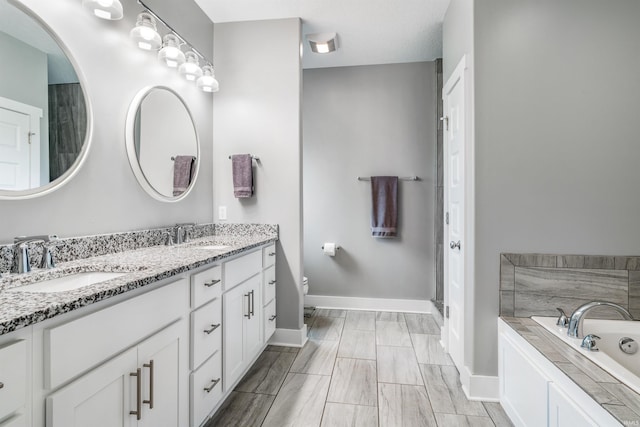 13606 Paperbark Trl, Fort Wayne, IN 46814 - full bath with double vanity, baseboards, a bath, and toilet