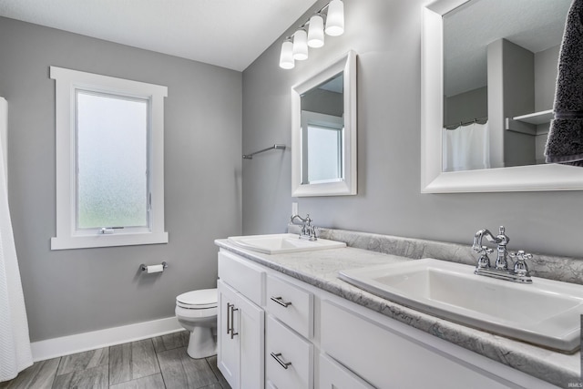 13606 Paperbark Trl, Fort Wayne, IN 46814 - bathroom featuring healthy amount of natural light, toilet, double vanity, and baseboards