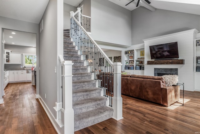 13606 Paperbark Trl, Fort Wayne, IN 46814 - staircase featuring hardwood / wood-style flooring, a ceiling fan, a fireplace, high vaulted ceiling, and recessed lighting