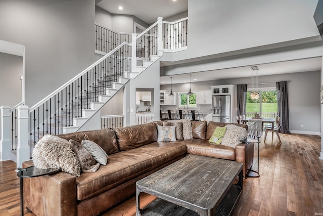 13606 Paperbark Trl, Fort Wayne, IN 46814 - living area featuring a high ceiling, hardwood / wood-style flooring, stairway, healthy amount of natural light, and baseboards