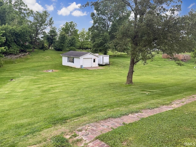 1238 W Wortman Rd, Evansville, IN 47725 - view of yard with an outdoor structure, a detached garage, and view of wooded area