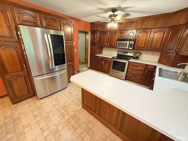 1238 W Wortman Rd, Evansville, IN 47725 - kitchen featuring appliances with stainless steel finishes, a sink, light countertops, a peninsula, and ceiling fan