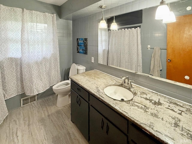 1238 W Wortman Rd, Evansville, IN 47725 - bathroom with tile walls, vanity, wood finished floors, toilet, and a shower with shower curtain