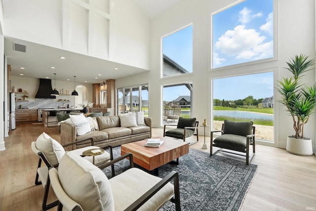 17807 Milazzo Cv, Huntertown, IN 46748 - living area with a towering ceiling, light wood-style flooring, and a water view