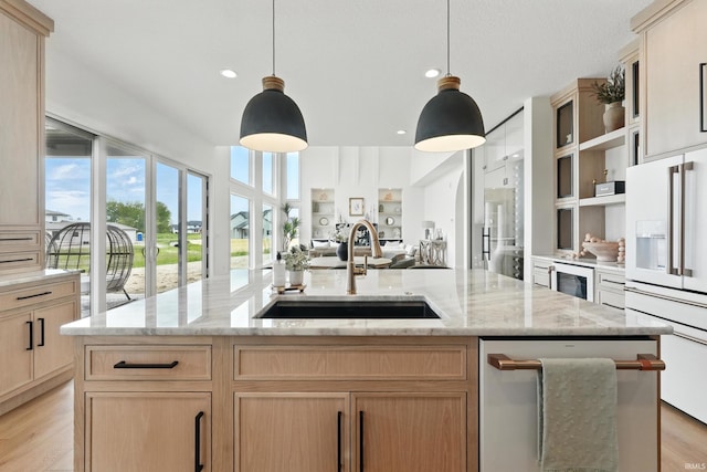 17807 Milazzo Cv, Huntertown, IN 46748 - kitchen featuring white refrigerator with ice dispenser, a sink, open floor plan, an island with sink, and light wood finished floors