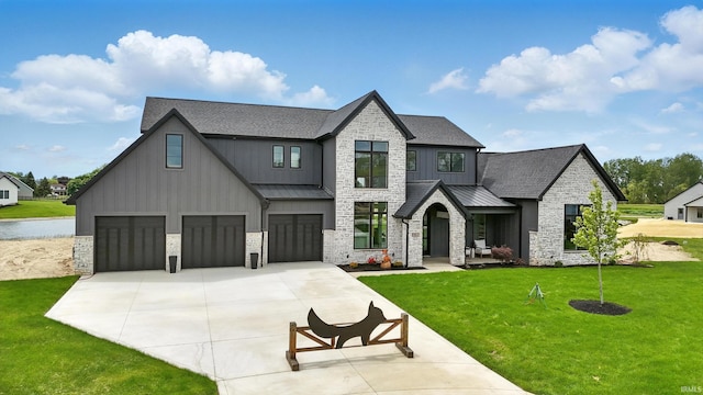 17807 Milazzo Cv, Huntertown, IN 46748 - view of front of property featuring a garage, a standing seam roof, concrete driveway, stone siding, and a front yard