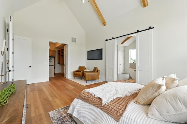 17807 Milazzo Cv, Huntertown, IN 46748 - bedroom featuring a barn door, light wood finished floors, high vaulted ceiling, a spacious closet, and beam ceiling