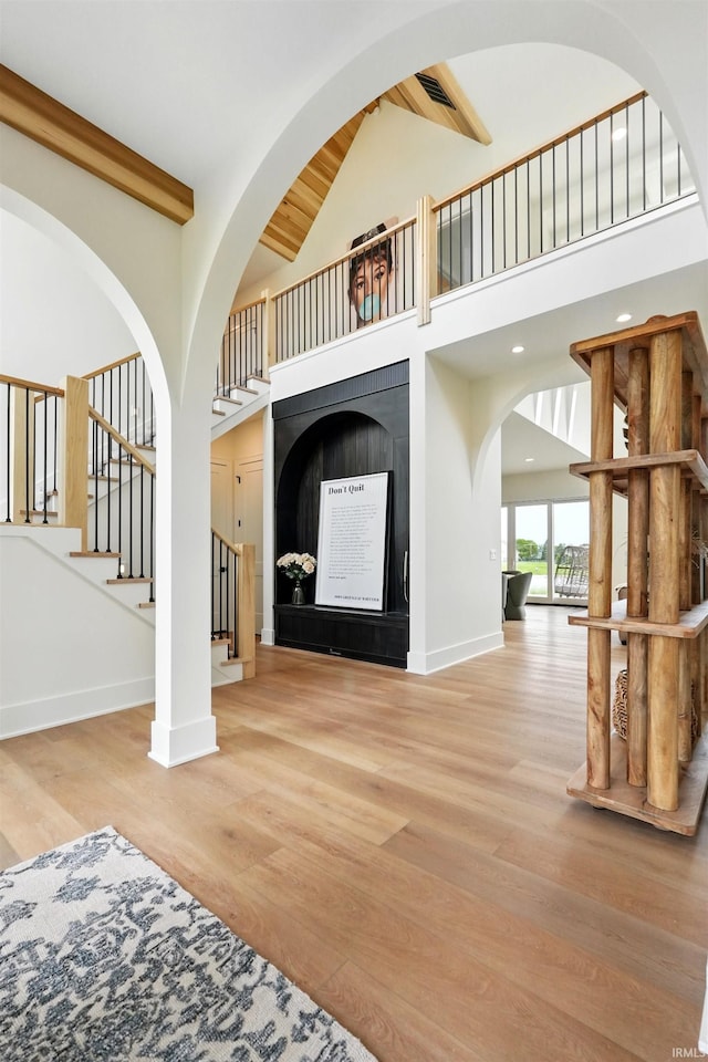 17807 Milazzo Cv, Huntertown, IN 46748 - unfurnished living room with stairs, wood finished floors, baseboards, a fireplace, and arched walkways