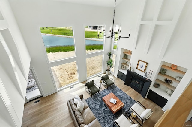 17807 Milazzo Cv, Huntertown, IN 46748 - living room with a high ceiling, wood finished floors, a water view, a chandelier, and built in features