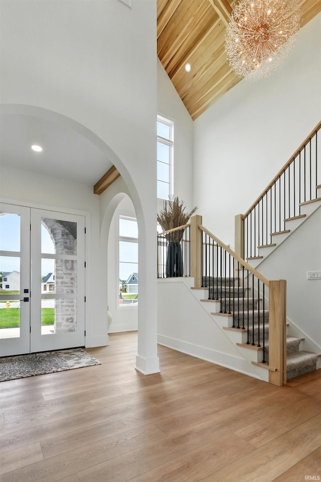 17807 Milazzo Cv, Huntertown, IN 46748 - foyer featuring healthy amount of natural light, high vaulted ceiling, stairs, arched walkways, and wood finished floors