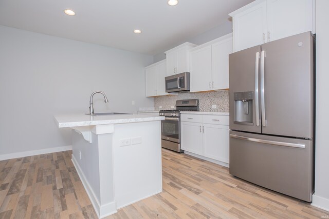 5110 Mustang Dr, Evansville, IN 47715 - kitchen with appliances with stainless steel finishes, a sink, light countertops, decorative backsplash, and white cabinetry