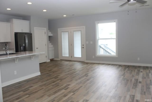 5110 Mustang Dr, Evansville, IN 47715 - kitchen featuring stainless steel refrigerator with ice dispenser, dark wood-style flooring, white cabinetry, light countertops, and a kitchen bar