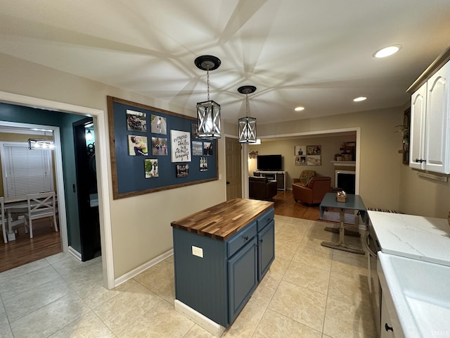 212 Alexandria Dr, Newburgh, IN 47630 - kitchen with wood counters, white cabinets, recessed lighting, light tile patterned floors, and hanging light fixtures