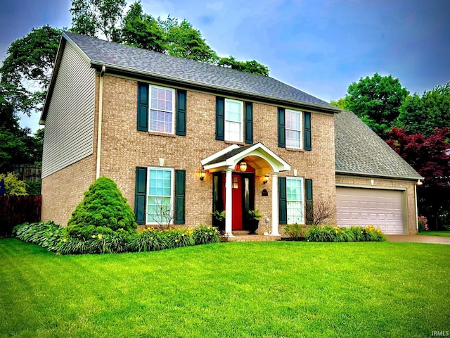 212 Alexandria Dr, Newburgh, IN 47630 - colonial inspired home with brick siding, a front yard, an attached garage, and driveway
