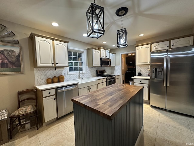 212 Alexandria Dr, Newburgh, IN 47630 - kitchen featuring stainless steel appliances, butcher block countertops, tasteful backsplash, decorative light fixtures, and light tile patterned floors
