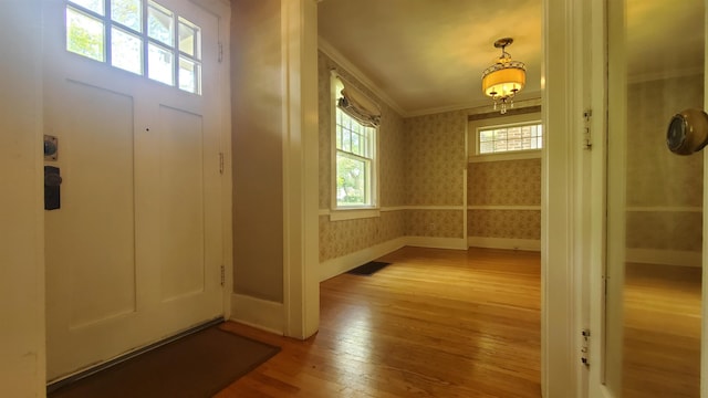 447 Englewood Ct, Fort Wayne, IN 46807 - entryway with wallpapered walls, crown molding, wood-type flooring, baseboards, and a chandelier