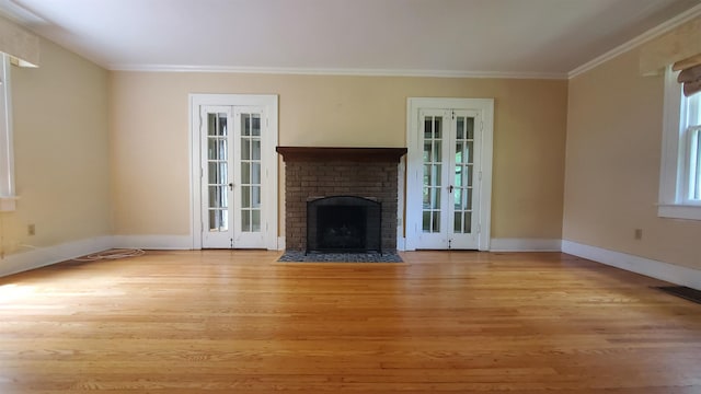 447 Englewood Ct, Fort Wayne, IN 46807 - unfurnished living room featuring wood finished floors, ornamental molding, baseboards, a brick fireplace, and french doors