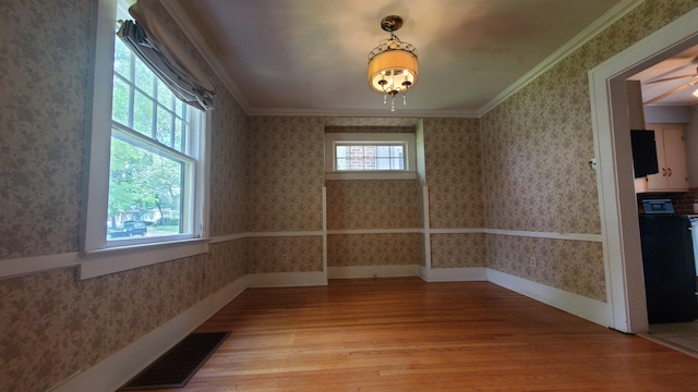 447 Englewood Ct, Fort Wayne, IN 46807 - unfurnished dining area with wood finished floors, wallpapered walls, crown molding, and baseboards