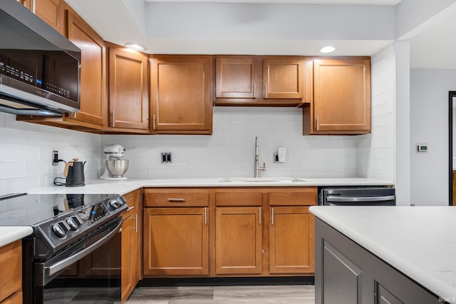 9531 Ledge Wood Ct, Fort Wayne, IN 46804 - kitchen featuring appliances with stainless steel finishes, a sink, light countertops, light wood-style flooring, and backsplash