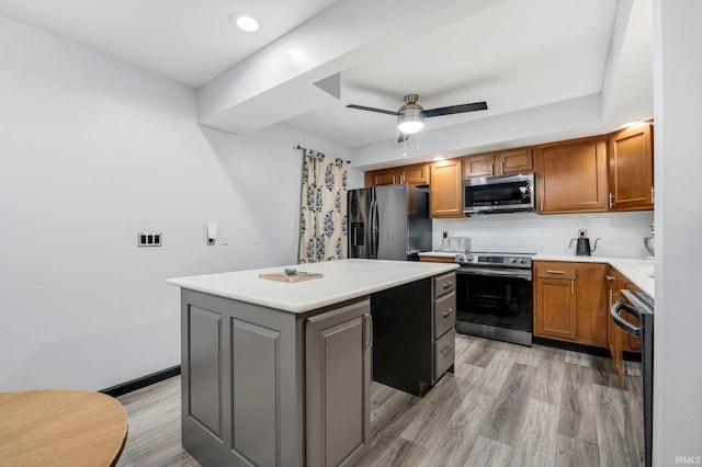 9531 Ledge Wood Ct, Fort Wayne, IN 46804 - kitchen with stainless steel appliances, a center island, light wood-style flooring, ceiling fan, and decorative backsplash