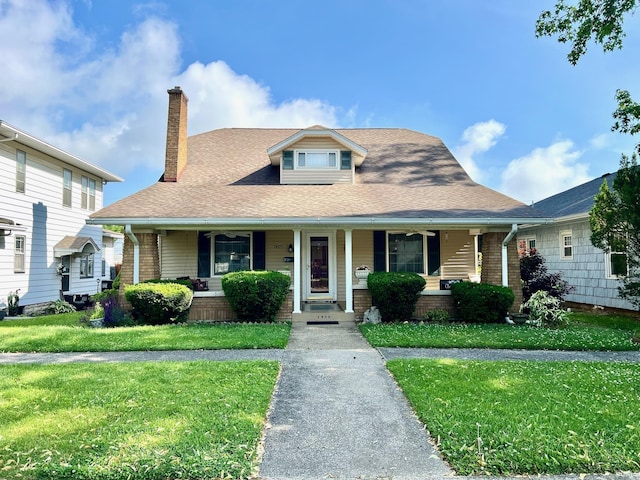 1405 19th St, Bedford, IN 47421 - view of front of property with a chimney, covered porch, a front lawn, and roof with shingles