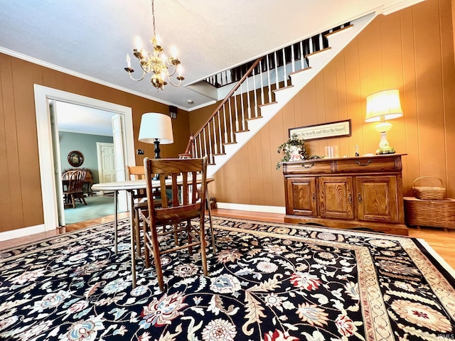 1405 19th St, Bedford, IN 47421 - dining space with wood finished floors, a chandelier, stairs, crown molding, and baseboards