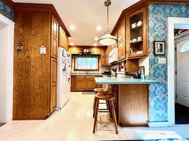 1405 19th St, Bedford, IN 47421 - kitchen featuring white appliances, wallpapered walls, brown cabinetry, a sink, and light wood finished floors