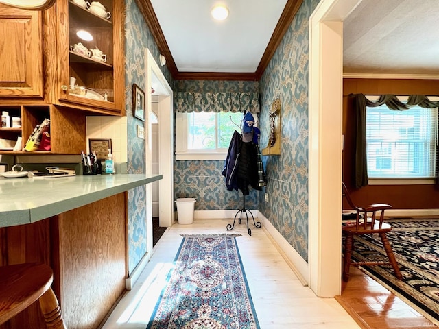1405 19th St, Bedford, IN 47421 - kitchen with wallpapered walls, crown molding, light wood finished floors, brown cabinets, and baseboards