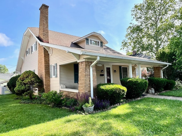 1405 19th St, Bedford, IN 47421 - view of front of house featuring a front lawn, a chimney, covered porch, and a shingled roof