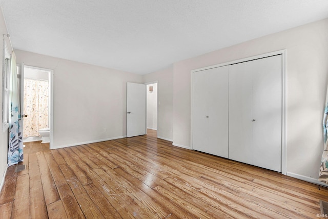 6420 Londonderry Ln, Fort Wayne, IN 46835 - unfurnished bedroom featuring wood-type flooring, a closet, baseboards, and connected bathroom