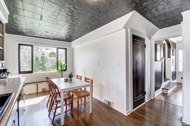 1920 Kenwood Ave, Fort Wayne, IN 46805 - dining space featuring dark wood-style flooring, healthy amount of natural light, arched walkways, baseboards, and crown molding
