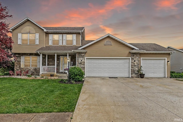 54062 Stonebridge Dr, Elkhart, IN 46514 - traditional-style house with a porch, a garage, concrete driveway, stone siding, and a lawn