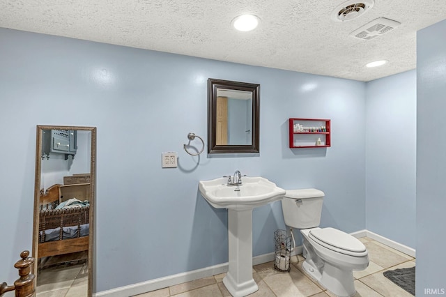 54062 Stonebridge Dr, Elkhart, IN 46514 - half bath featuring toilet, a textured ceiling, baseboards, tile patterned floors, and a sink