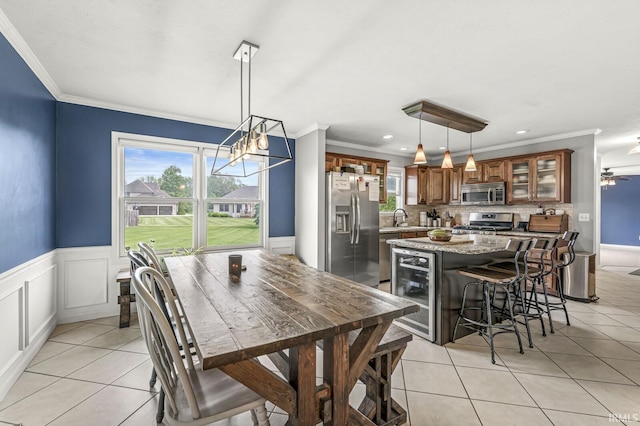 54062 Stonebridge Dr, Elkhart, IN 46514 - dining area with wine cooler, crown molding, light tile patterned flooring, wainscoting, and recessed lighting
